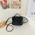 Mini black crossbody bag for girls featuring a cute bow and white contrast stitching detail - Black