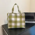 Borsa tote in tela a quadretti bianchi e verdi con doppi manici su tavolo in legno - Verde