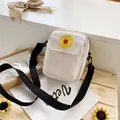 Cream canvas crossbody bag with sunflower embroidery and adjustable black strap - White