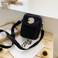 Black canvas crossbody bag with white daisy embroidery and adjustable strap - Black