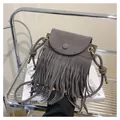 Detail of grey suede crossbody bag featuring long fringes and bohemian knot strap - Gray
