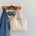 Large beige canvas tote bag with pink straps and side pockets for daily commuting - White