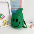 Detailed close-up of a green nylon kids chest bag featuring a playful black smiley face design - Green