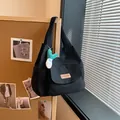 Minimalist black canvas tote bag featuring front pocket and green plush keychain charm - With Pendant / Black