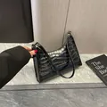 Glanzende zwarte baguette tas met krokodillenpatroon en zilveren ritsdetail - Zwart