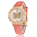 Detailed macro view of rhinestone bezel watch with butterfly dial and gold leaf charm - Orange Watch Only
