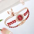Detailed shot of rose gold jewelry watch with red leaf stones and adjustable beads - Red