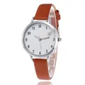 Detail of round silver watch case with white dial and textured brown leather strap - Brown