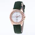 Macro shot of rose gold watch bezel with diamonds and dark green suede strap details - Green