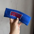 Détail macro du bandeau en maille marine avec broderie rouge Strive Power en lettres - Bleu royal
