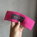 Gros plan du bandeau de sport rose en maille avec lettrage STRIVE POWER vert brodé - Rose rouge