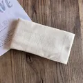Detailed view of cream knitted headband texture on a natural wooden background - Beige