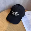 Dettaglio di un cappello da baseball nero ad asciugatura rapida con ricami bianchi - Regolabile / Nero