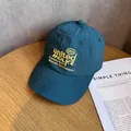 Detailaufnahme der pfauenblauen Baseballkappe mit gelber Stickerei und fünffacher Kappennähte - Verstellbar / Grün
