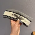 Detail of grey and white knitted sports headband with ARVB lettering and checkered stripes - Beige + Gray