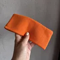 Vue détaillée d'un bandeau de sport en tricot orange vif montrant la texture du tissu - Orange