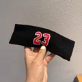 Dettaglio della fascia sportiva nera con numero 23 ricamato in rosso e bordo bianco - Nero