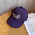 Dettaglio del cappellino viola scuro ad asciugatura rapida con ricamo su legno - Regolabile / Viola