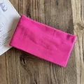 Close-up of rose red knitted headband showing soft fabric texture on a wooden table - Rose Red