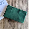 Detail of dark green knitted headband texture on a wooden table with casual lifestyle setting - Dark Green