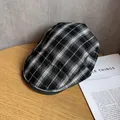 Detailopname van zwart-wit geruite platte pet op een rustiek houten oppervlak - M / Zwart-wit geruit