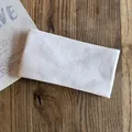 Dettaglio della fascia per capelli in maglia bianca morbida su legno naturale - Bianco