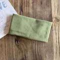 Detail of grass green knitted headband with vertical rib texture on wood surface - Light Green