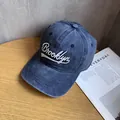 Dettaglio del ricamo Brooklyn su un cappellino vintage blu lavato su un tavolo di legno - Blu navy