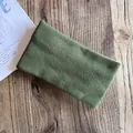 Close-up of dark green knitted headband with vertical texture on a wooden background - Army Green