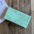 Detailed view of mint green knitted headband texture on rustic dark wood background - Mint Green