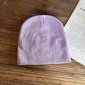 Texture dettagliata del berretto in maglia lavanda su tavolo di legno con rivista - M / Viola
