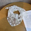 Close-up of white floral lace scarf texture on a warm wooden background with a magazine - Five Petal