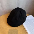 Detalle de gorra negra en ante sintético mostrando costuras finas sobre superficie de madera - Ajustable (55-59cm) / Negro