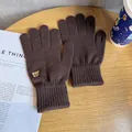 Macro detail of brown knitted gloves with cute bear embroidery and touchscreen finger slits - One Size / Coffee