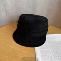 Detail of black suede bucket hat with triple-layered pleated band on wood table - M (55-59cm) / Black