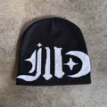Detail shot of black knitted beanie with white jacquard star and moon street art patterns - M / Black and White Lettering