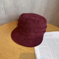 Detail of wine red suede bucket hat with pleated layers on light wooden table - M (55-59cm) / Burgundy