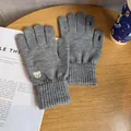 Close-up of gray knitted gloves with bear embroidery and touch screen finger openings - One Size / Gray