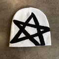 Vue détaillée à plat d'un bonnet en maille blanc avec un motif d'étoile noire - M / Blanc