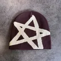 Détail d'un bonnet en tricot d'hiver avec motif étoile blanche sur tissu marron foncé - M / Café