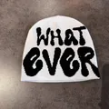Close-up of white knitted beanie with black WHAT EVER jacquard lettering and thick texture - M (54-59cm) / White