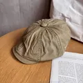 Detail of khaki cotton newsboy cap with stitching and button on a rustic wooden table - M (55-59cm) / Khaki