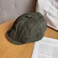 Close-up of vintage dark green cotton beret with white side embroidery on wooden table - M (55-59cm) / Army Green