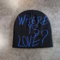 Top view of black knitted beanie with blue Where Is Love? text on grey surface - M (52-58cm) / Black with Blue Letter