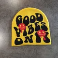 Close-up of yellow knit beanie featuring Good Vibes Only text and melting smiley faces - M / Yellow