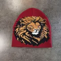 Gros plan du bonnet en tricot rouge foncé avec motif de lion tissé détaillé et texture - M (52-58cm) / Bordeaux