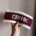 Macro shot of knitted wide headband in burgundy with white Crank jacquard lettering - Burgundy