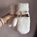 Dettaglio di muffole bianche in peluche con toppe a cuore e fiori a maglia per l'inverno - Bianco