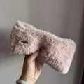Detail of pink faux fur winter headband featuring a soft fluffy texture and gold metal logo - Pink