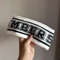 Macro-detail van witte gebreide elastische hoofdband met letters en zwarte randen - Wit